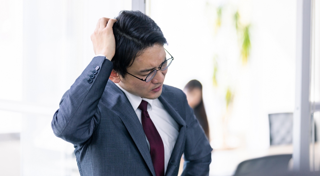頭を抱えている男性